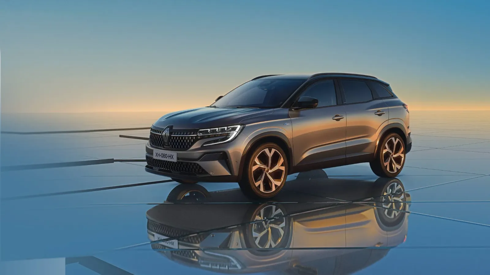 Renault Austral gris sobre un suelo de cristal que lo refleja, con el cielo del atardecer de fondo